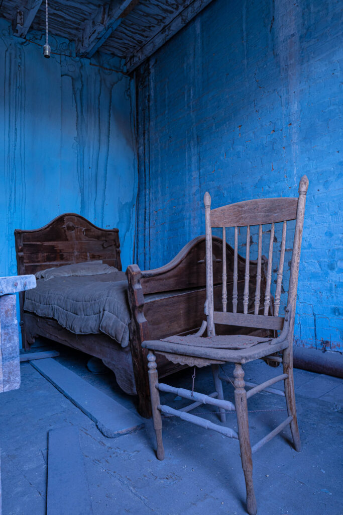 Old furniture appears to float in the intense Cobalt paint covering the walls and floor of this abandoned room.